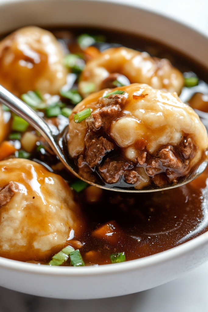 A close-up of a serving of beef stew in a rustic ceramic bowl, showcasing succulent beef, fluffy dumplings, and vibrant vegetables in a thick, flavorful broth. The dish is garnished with finely chopped parsley for a fresh finishing touch.