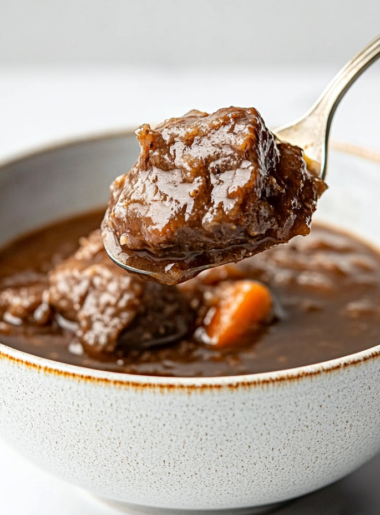 This image shows the Ninja Foodi pot filled with browned beef, ale, chopped onions, carrots, and celery, ready to slow cook into a rich and hearty stew."